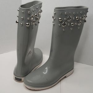 A worn pair of Stuart Weitzman studded rain boots